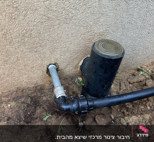 צינור מים מחובר לקיר עם אדמה מסביב